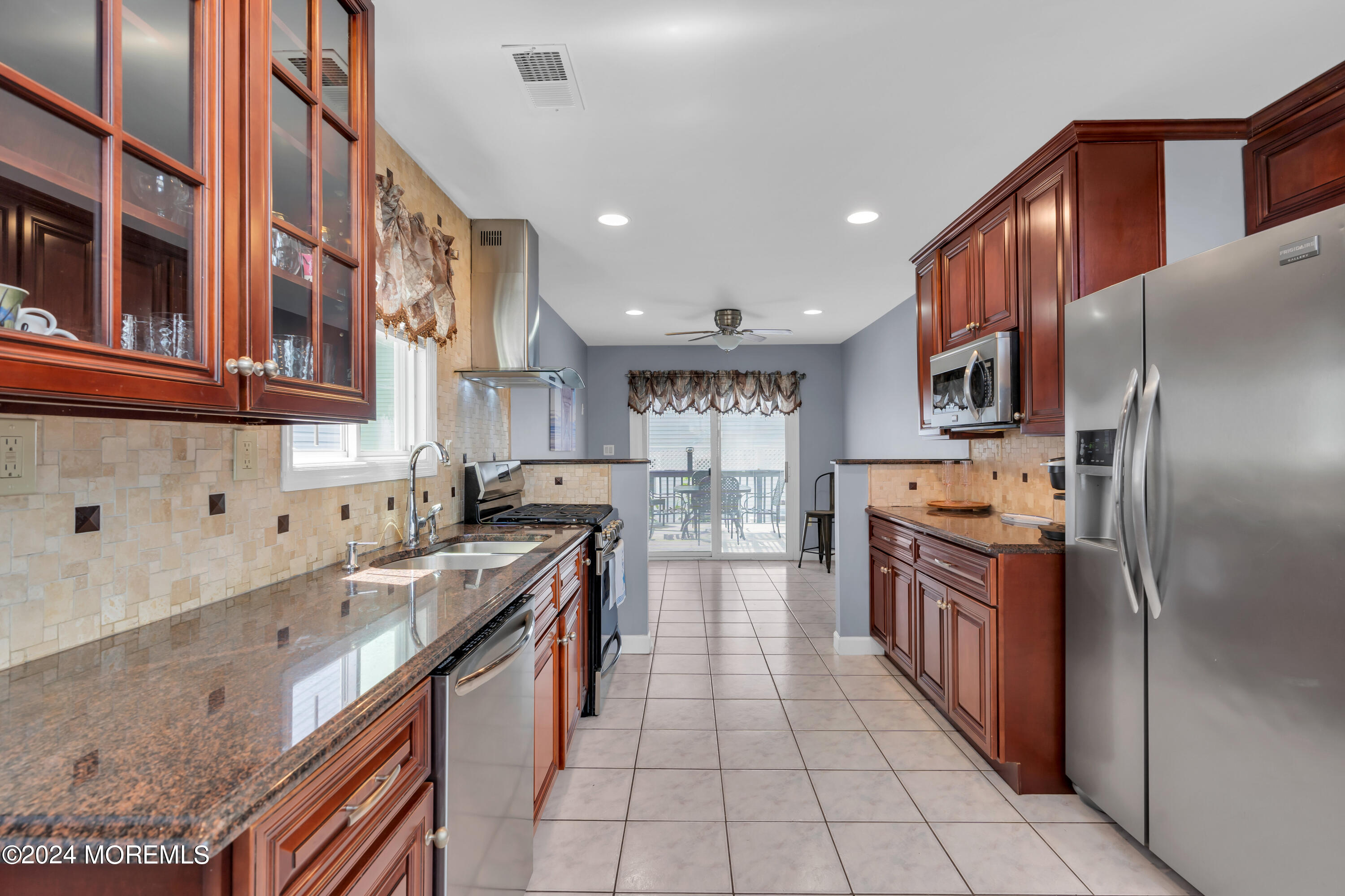 117 Harding Avenue Seaside Heights, NJ 08751 - Photo 10 of 28 a kitchen with stainless steel appliances granite countertop a refrigerator a stove and a sink with wooden cabinets