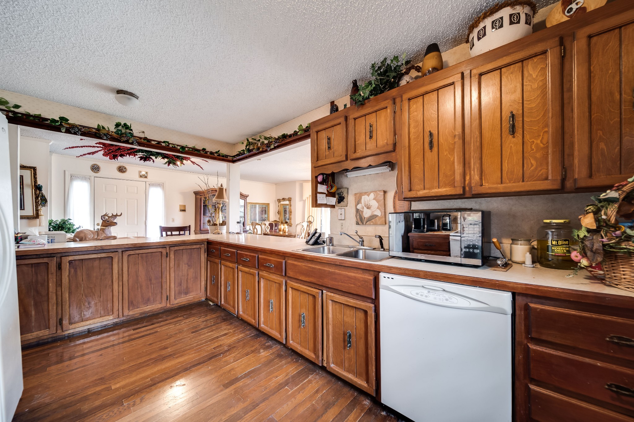 6040 New Cut Road Springfield, TN 37172 - Photo 11 of 37 a kitchen with granite countertop wooden cabinets a sink and dishwasher a stove with wooden floor