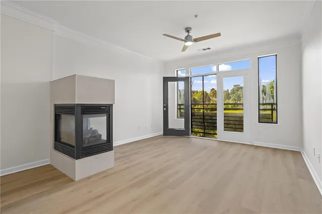 a view of an empty room with a fireplace and a window