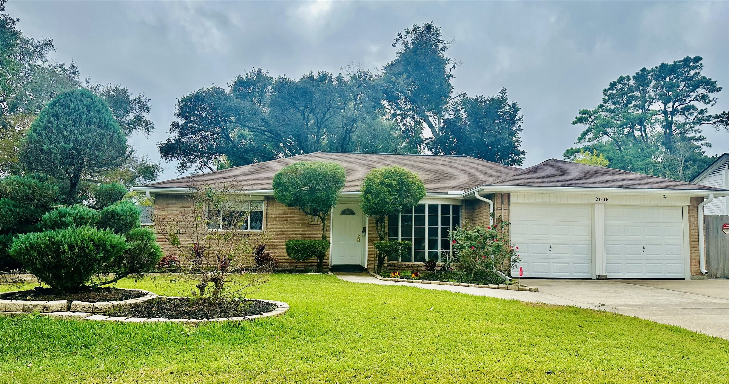 2006 Seagate Lane Houston, TX 77062 - Photo 1 of 22 a front view of a house with a garden and plants