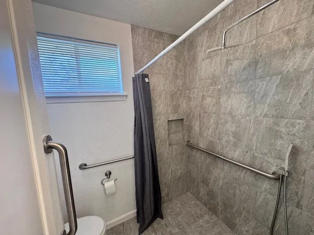 a bathroom with a toilet and a shower