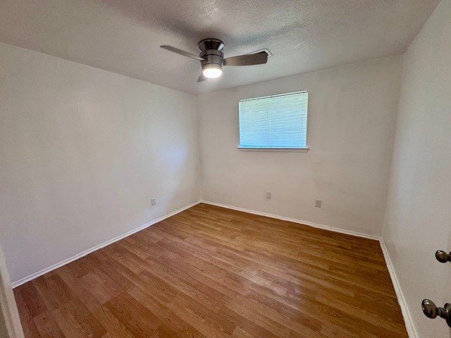2006 Seagate Lane Houston, TX 77062 - Photo 18 of 22 an empty room with wooden floor ceiling fan and window