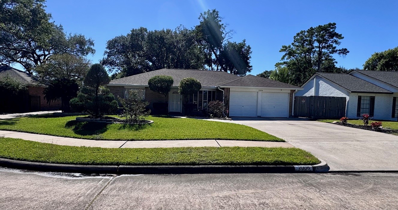 2006 Seagate Lane Houston, TX 77062 - Photo 2 of 22 a front view of a house with a garden and trees