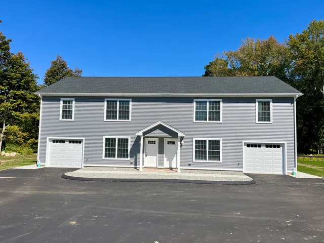 a front view of a house with a road