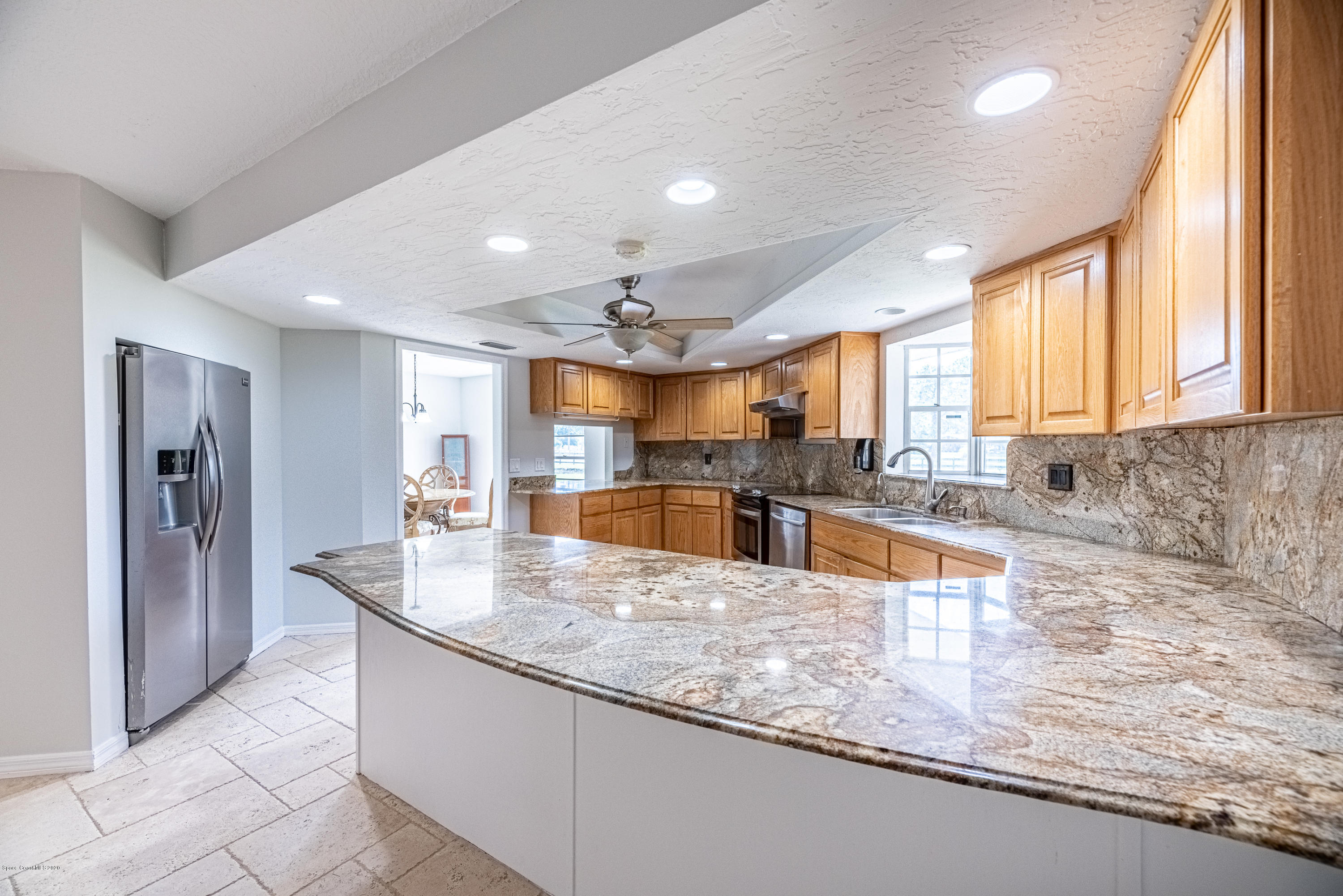 4300 Pinewood Road Melbourne, FL 32934 - Photo 14 of 60 a large kitchen with granite countertop a large counter top stainless steel appliances and windows