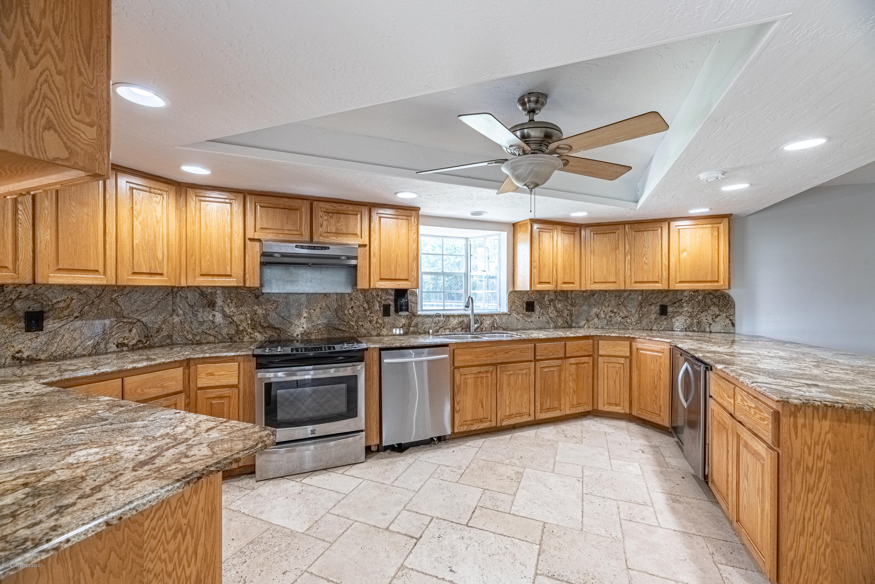 4300 Pinewood Road Melbourne, FL 32934 - Photo 15 of 60 a kitchen with stainless steel appliances granite countertop a stove sink and cabinets
