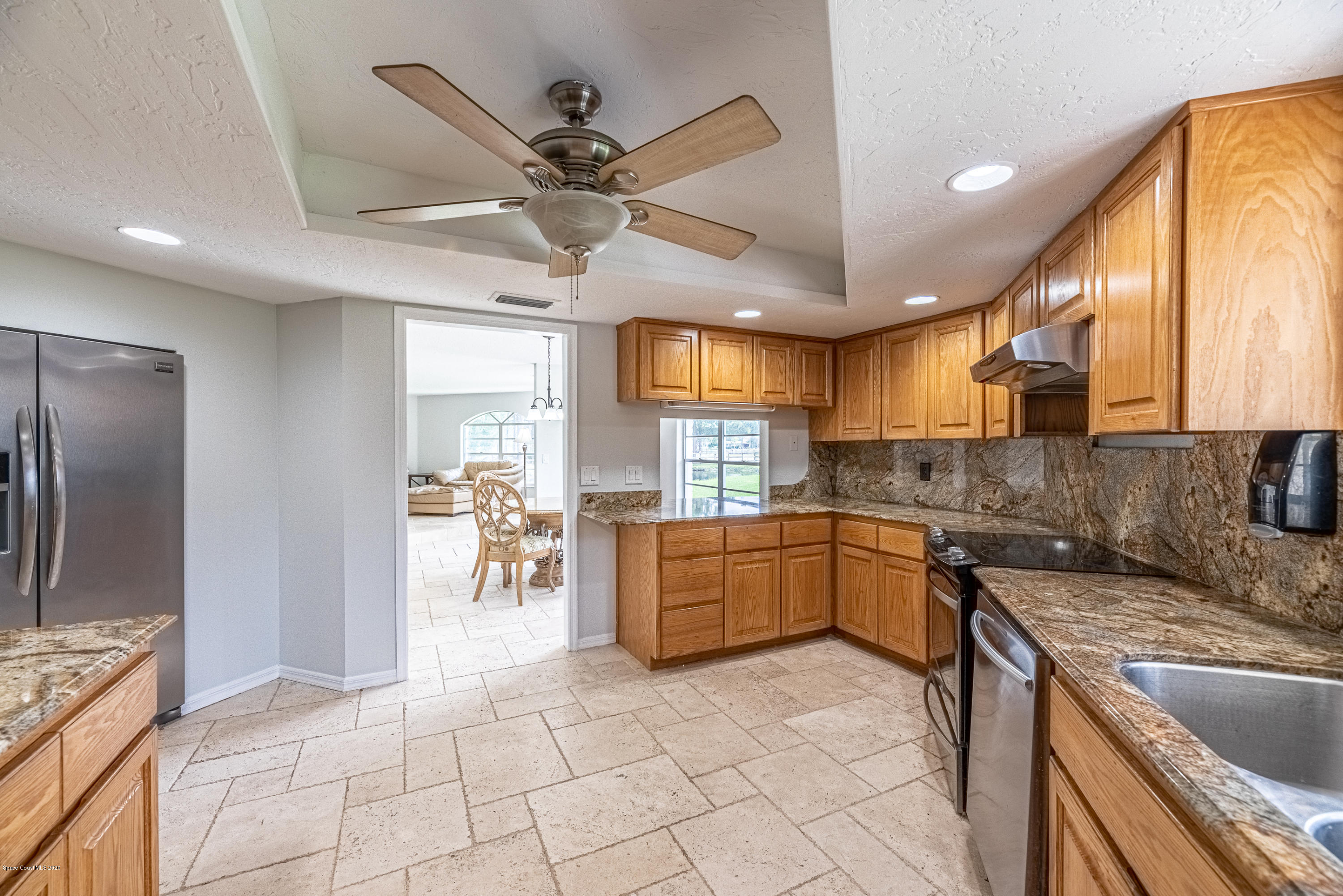 4300 Pinewood Road Melbourne, FL 32934 - Photo 16 of 60 a large kitchen with a large window a sink a counter space and stainless steel appliances