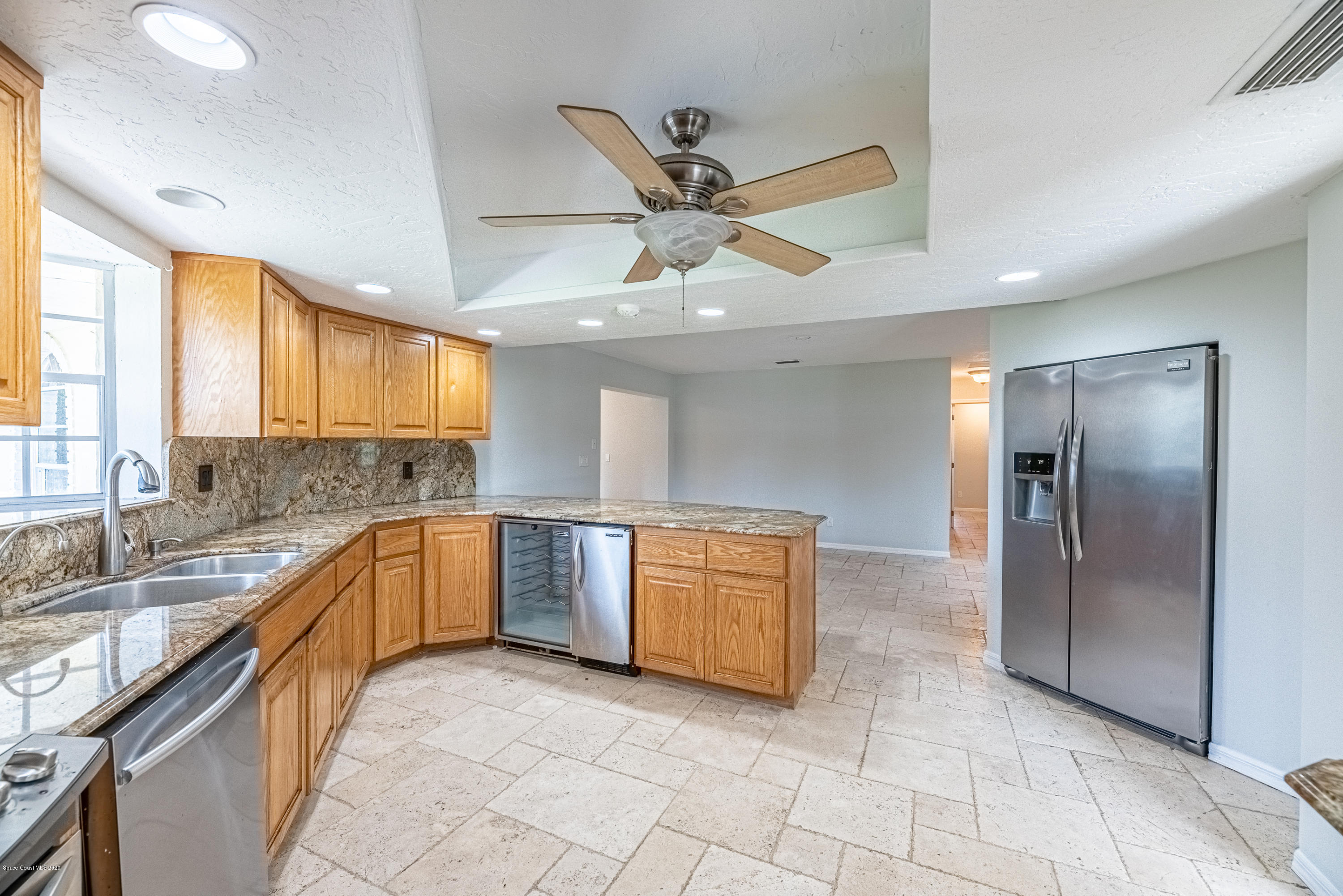 4300 Pinewood Road Melbourne, FL 32934 - Photo 18 of 60 a large kitchen with stainless steel appliances granite countertop a sink and cabinets