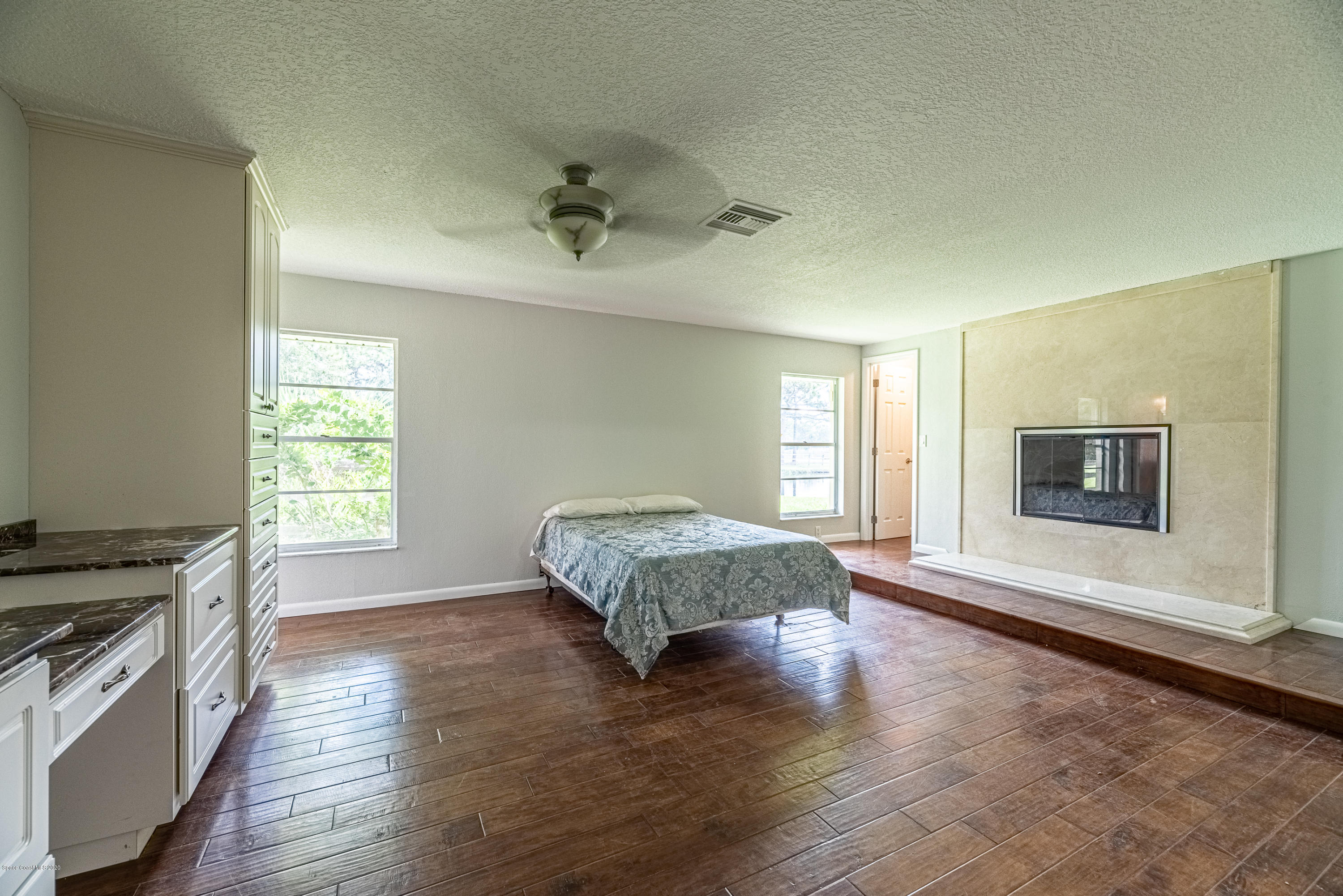 4300 Pinewood Road Melbourne, FL 32934 - Photo 22 of 60 a spacious bedroom with a bed and a flat screen tv