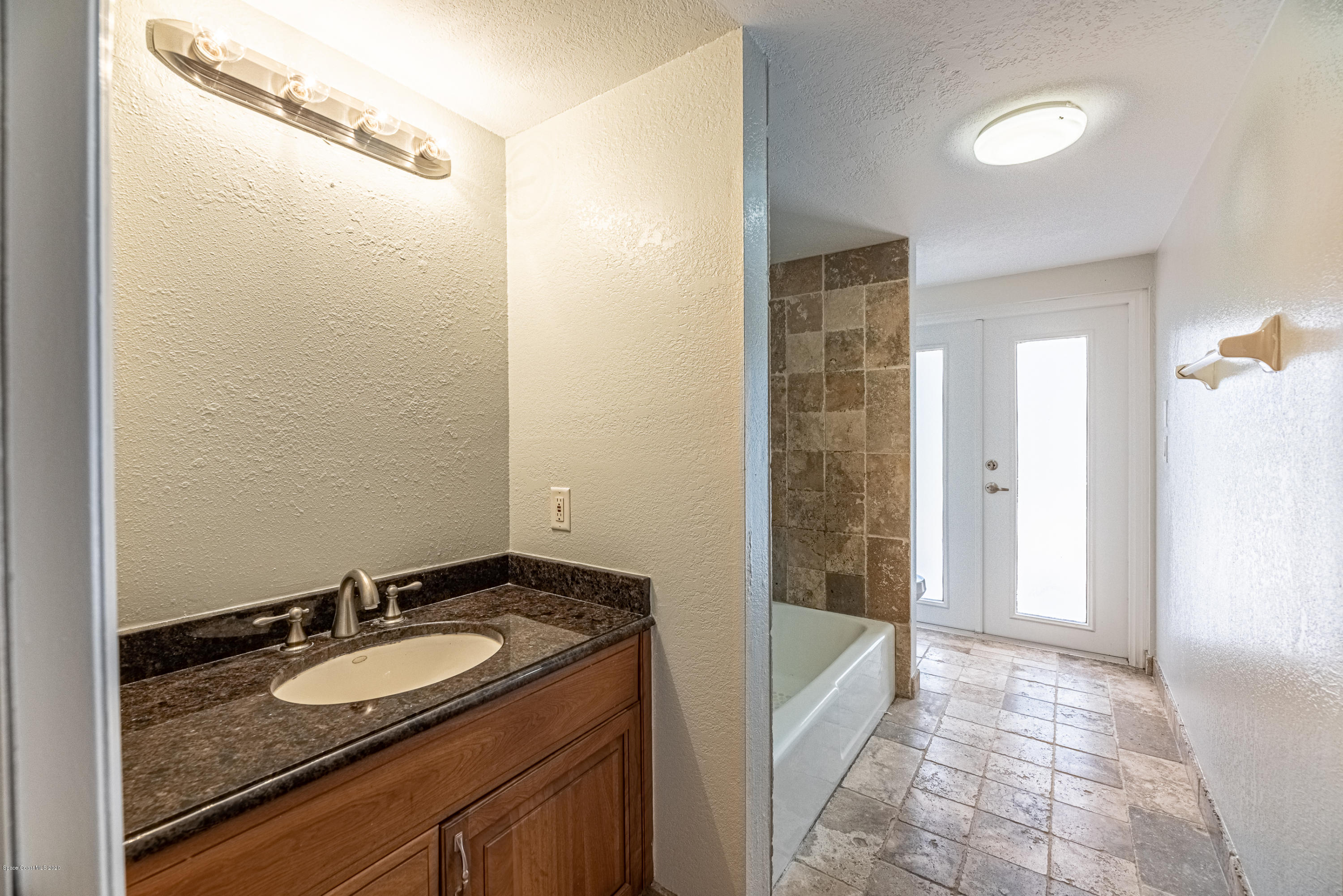 4300 Pinewood Road Melbourne, FL 32934 - Photo 30 of 60 a bathroom with a granite countertop sink and a mirror