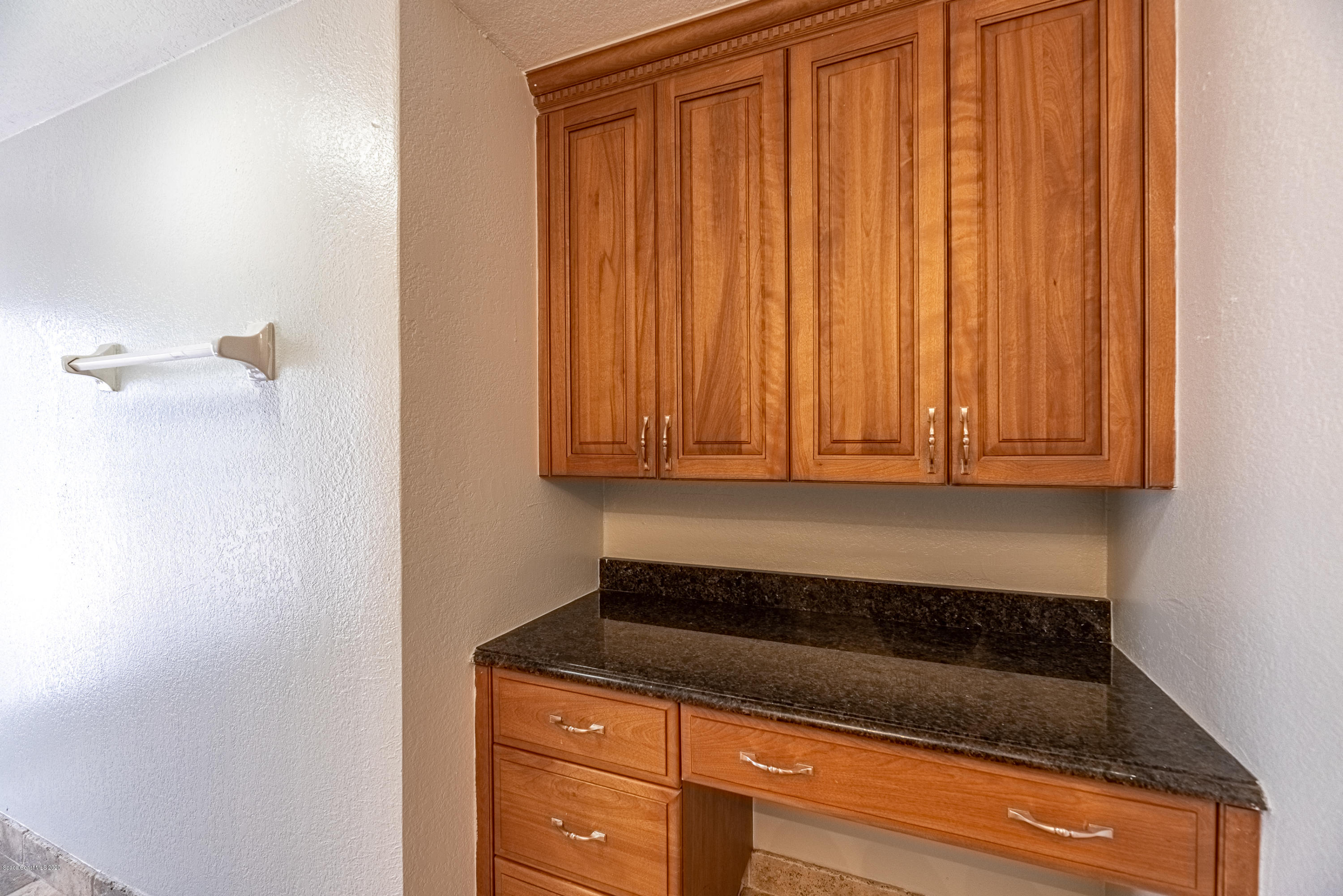 4300 Pinewood Road Melbourne, FL 32934 - Photo 32 of 60 a kitchen with granite countertop white cabinets and stainless steel appliances