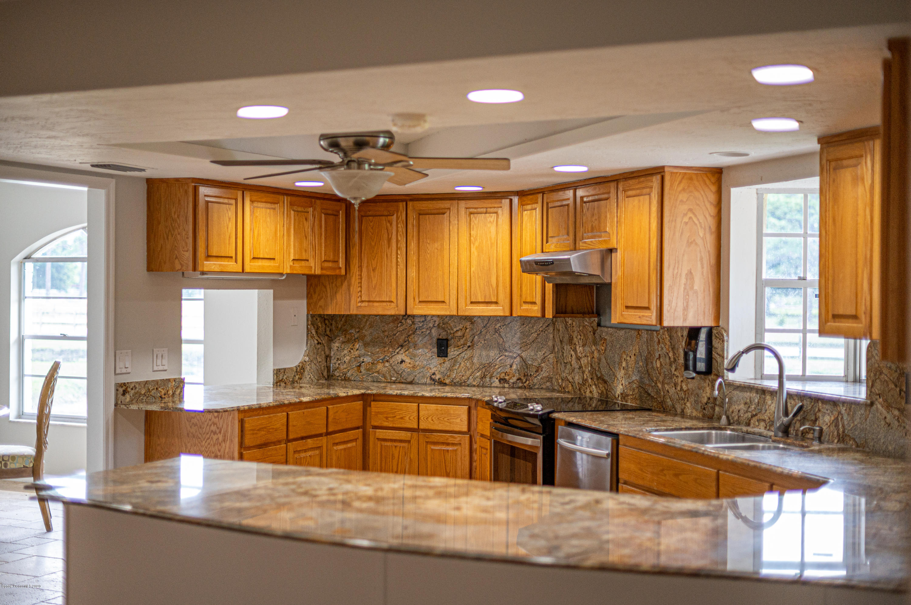 4300 Pinewood Road Melbourne, FL 32934 - Photo 44 of 60 a large kitchen with granite countertop a large window and a counter space