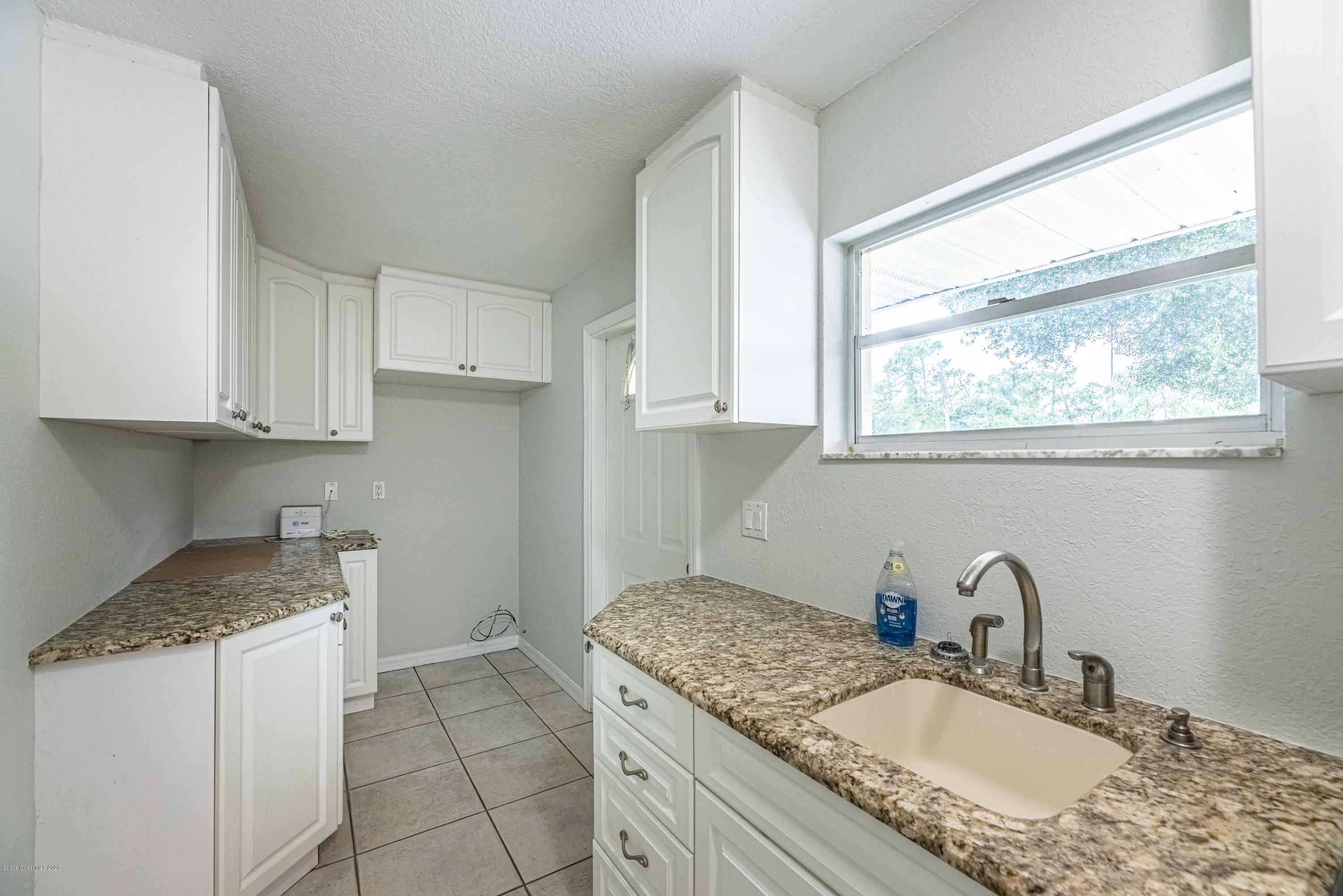 4300 Pinewood Road Melbourne, FL 32934 - Photo 50 of 60 a kitchen with granite countertop stainless steel appliances granite countertop a sink stove and cabinets