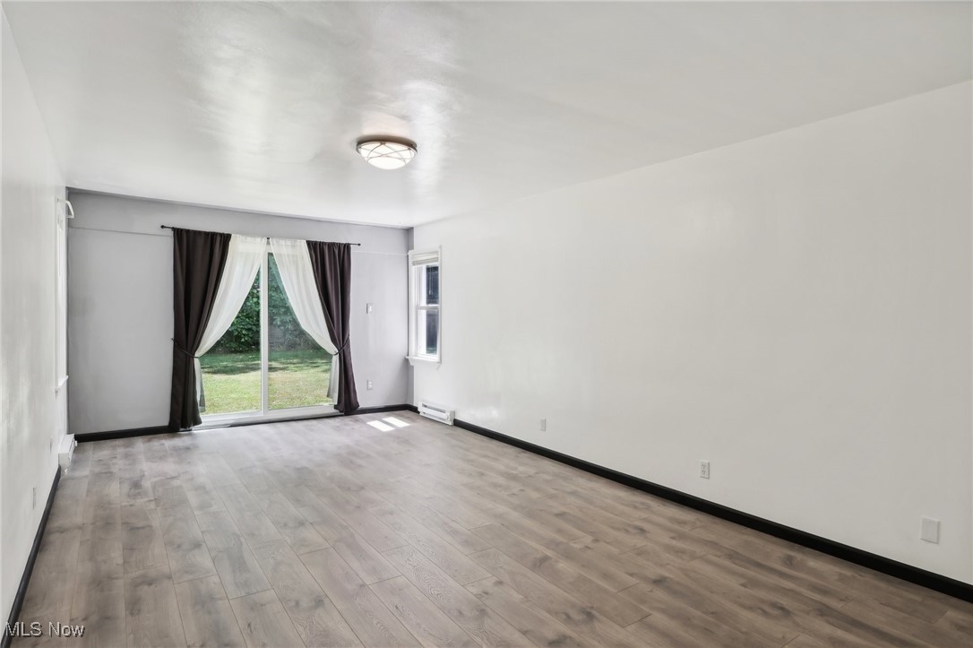 1829 Clyde Road Madison, OH 44057 - Photo 14 of 40 Empty room with hardwood / wood-style floors and a baseboard heating unit