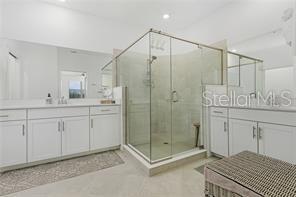 14132 Poppy Fld Loop, Unit 4022 Punta Gorda, FL 33955 - Photo 16 of 17 a bathroom with a shower sink and mirror