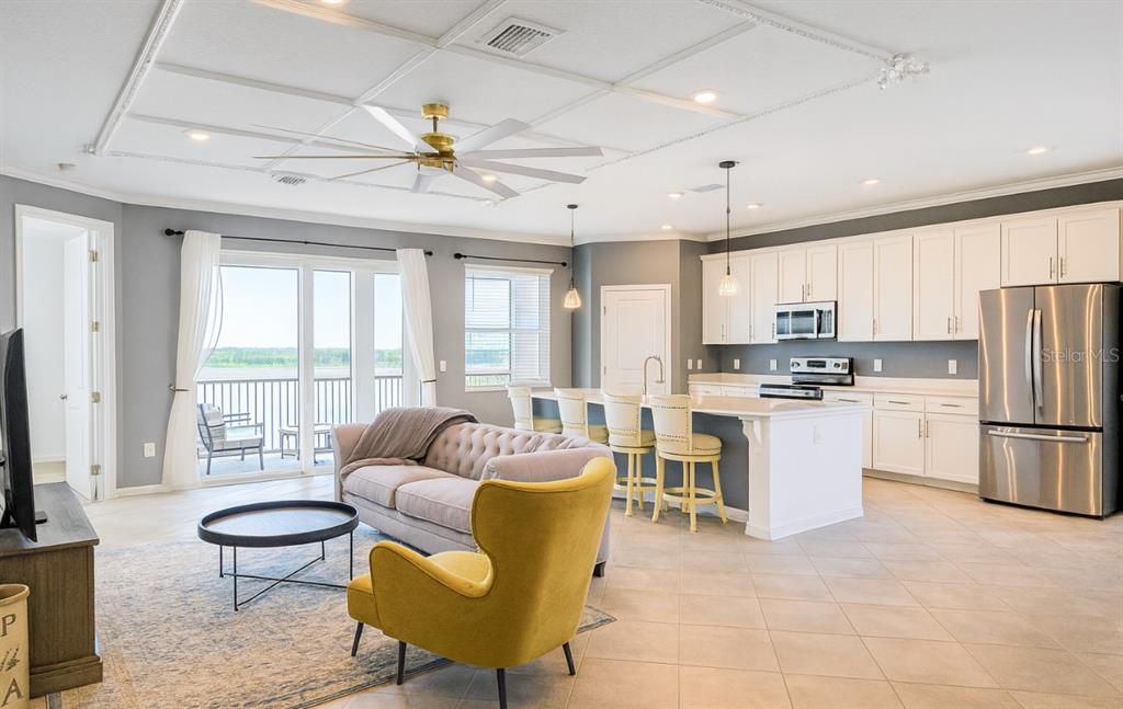 14132 Poppy Fld Loop, Unit 4022 Punta Gorda, FL 33955 - Photo 4 of 17 a living room with furniture a refrigerator and kitchen view