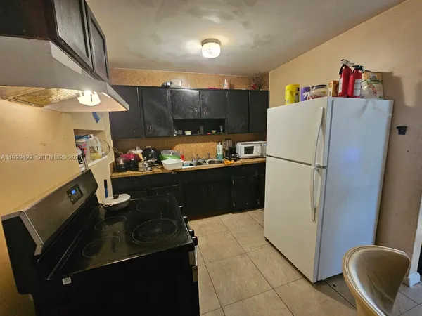 a kitchen with stainless steel appliances granite countertop a refrigerator a stove and a sink