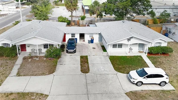 a aerial view of a white house couches chairs and a yard