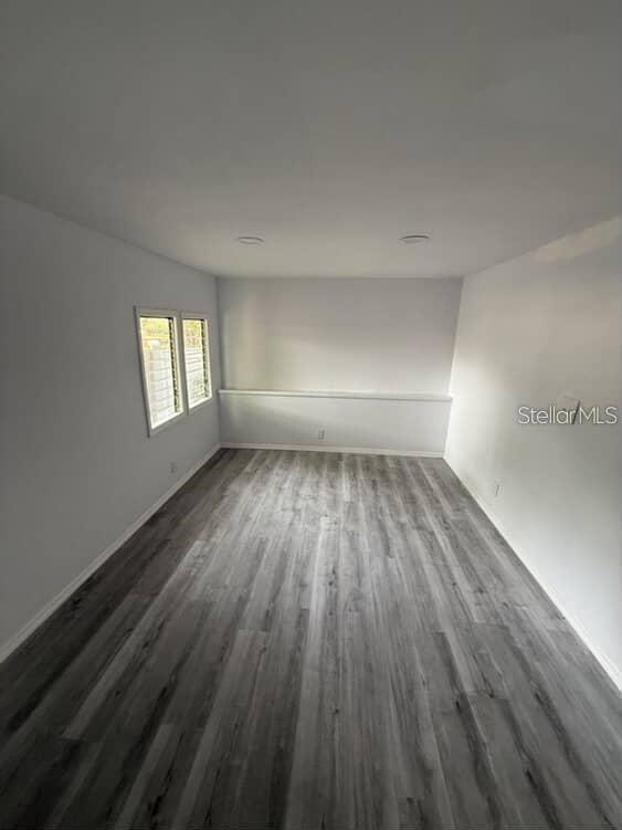 5500 North Rome Avenue, Unit 29 Tampa, FL 33603 - Photo 3 of 10 an empty room with wooden floor and windows