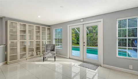 a living room with furniture a flat screen tv and kitchen view