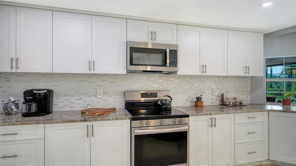 1523 84th Street Northwest Bradenton, FL 34209 - Photo 13 of 48 a kitchen with white cabinets and stainless steel appliances