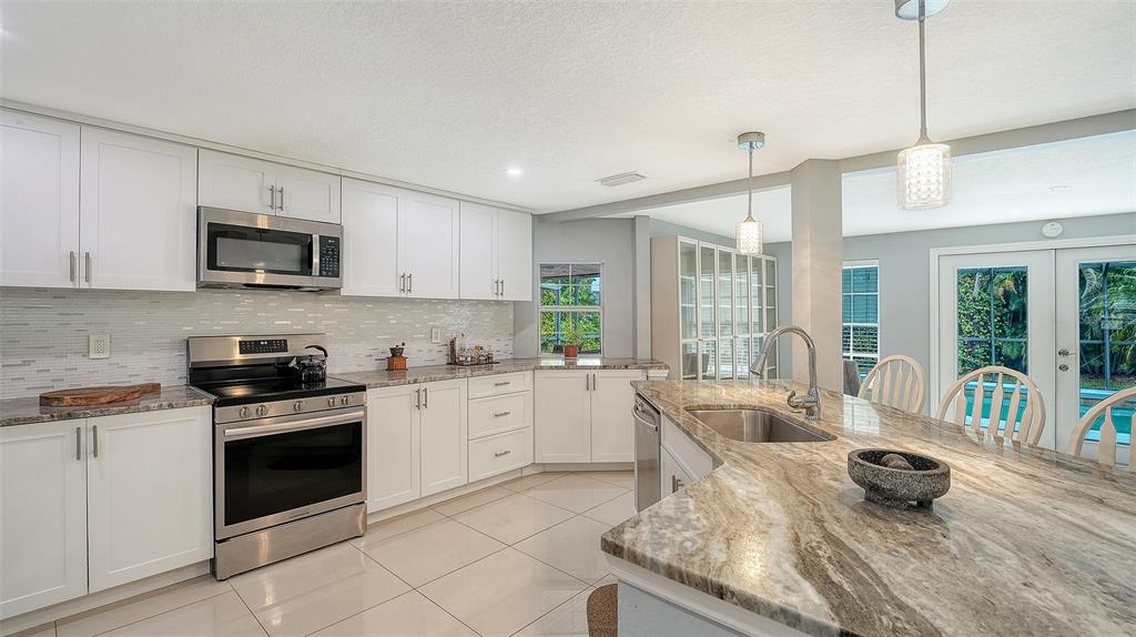 1523 84th Street Northwest Bradenton, FL 34209 - Photo 15 of 48 a kitchen with a stove a sink and a refrigerator