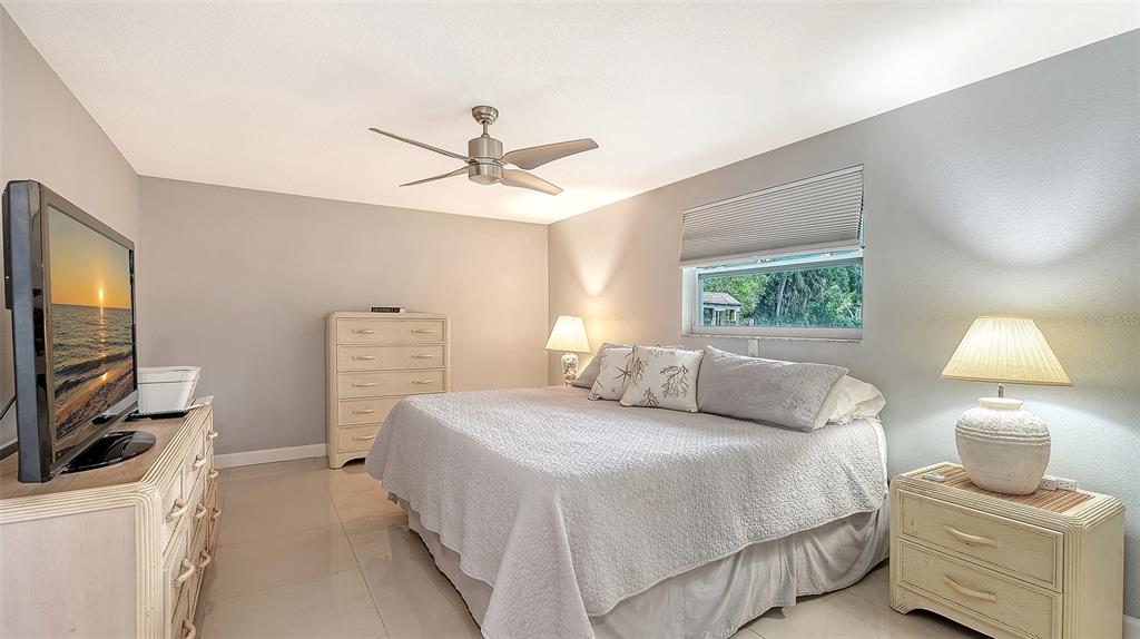 1523 84th Street Northwest Bradenton, FL 34209 - Photo 19 of 48 a bedroom with a bed a couch and a flat tv screen on the dresser