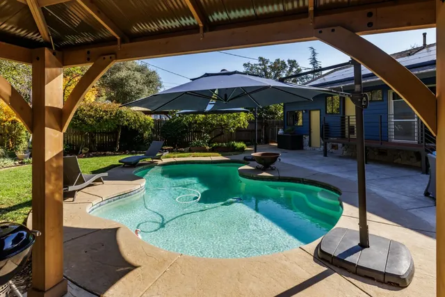 a view of a house with swimming pool and sitting area
