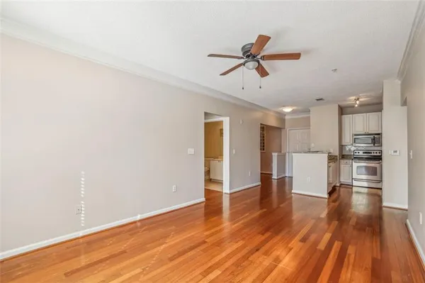 a view of empty room with wooden floor and window