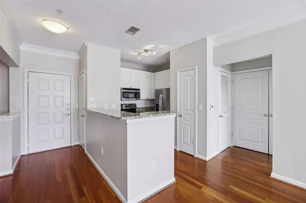 a kitchen with kitchen island wooden floors appliances and cabinets