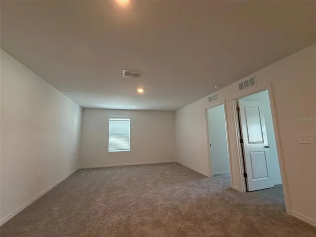 an empty room with windows and closet