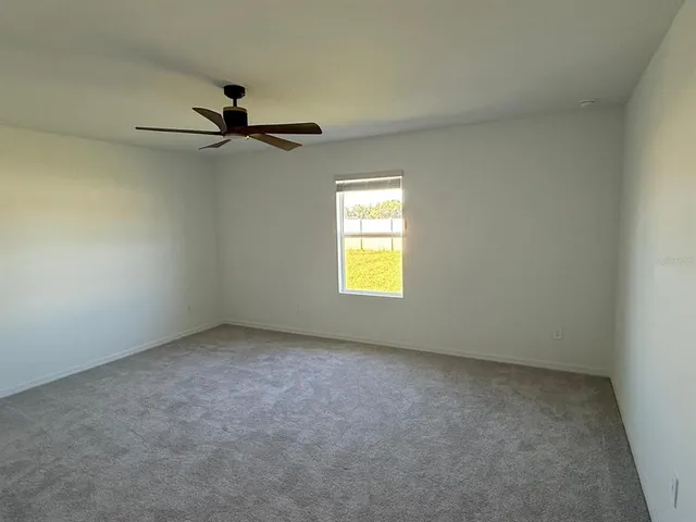 an empty room with a window and a fan