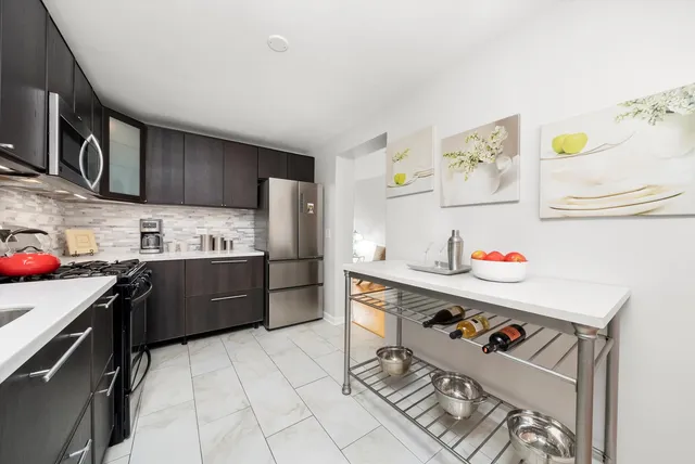 a kitchen with granite countertop a sink appliances and cabinets