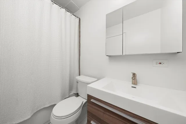 a white toilet sitting next to a bathroom sink