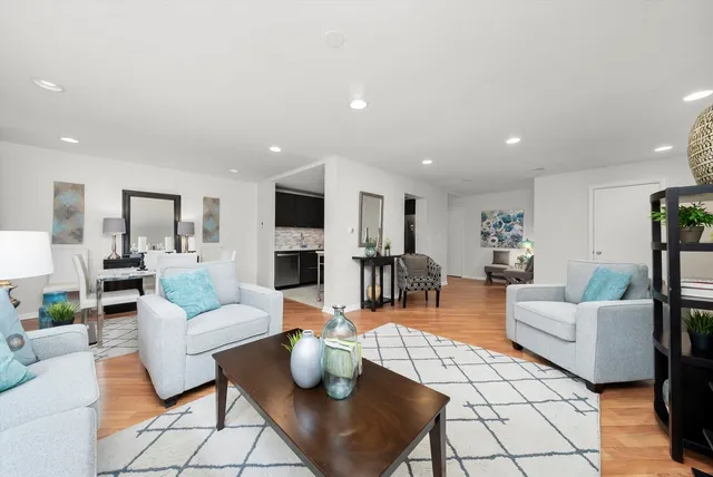 a living room with furniture and view of kitchen