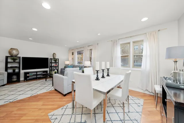 a living room with furniture a flat screen tv and kitchen view