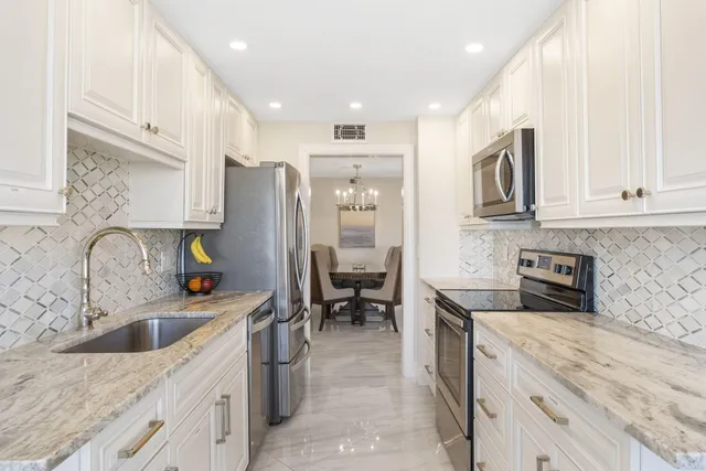 a kitchen with stainless steel appliances granite countertop a sink stove and refrigerator