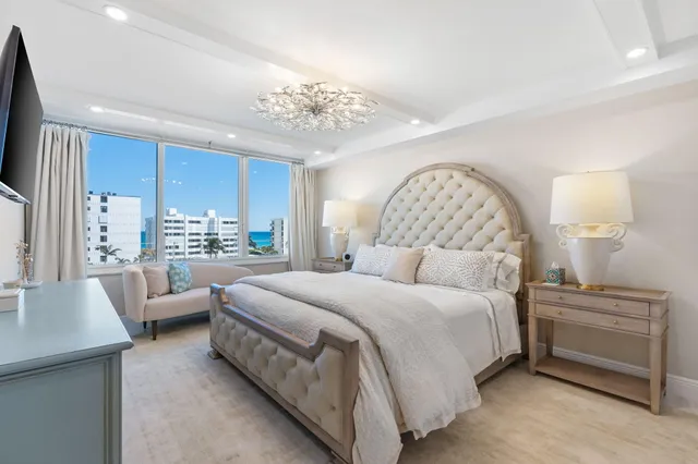 a bedroom with a large bed and a chandelier