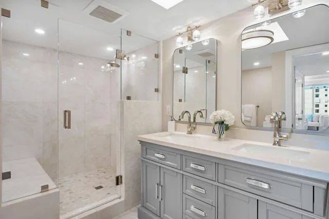 a bathroom with a double vanity sink mirror and shower