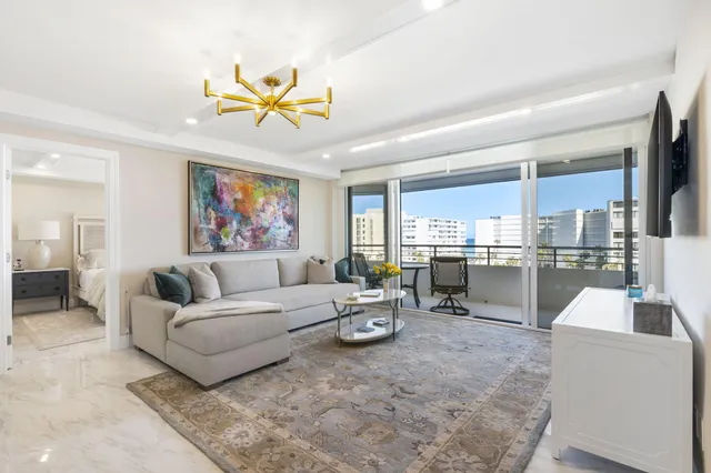 a living room with furniture kitchen view and a large window