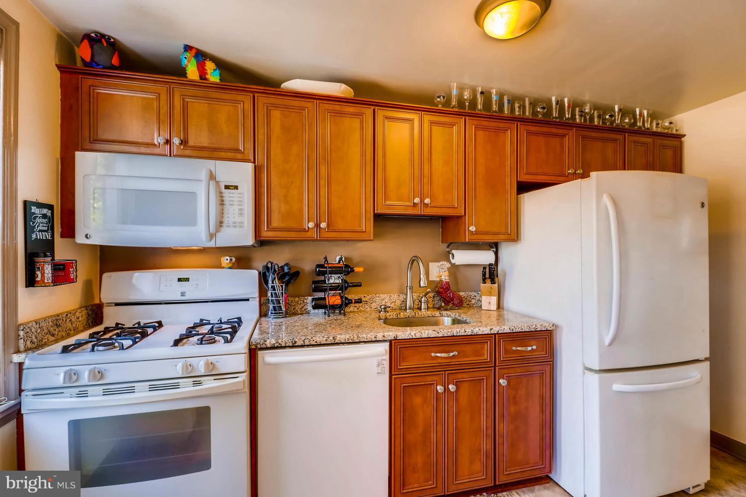 3703 Greenvale Road Baltimore, MD 21229 - Photo 7 of 24 a kitchen with refrigerator a stove a sink and cabinets