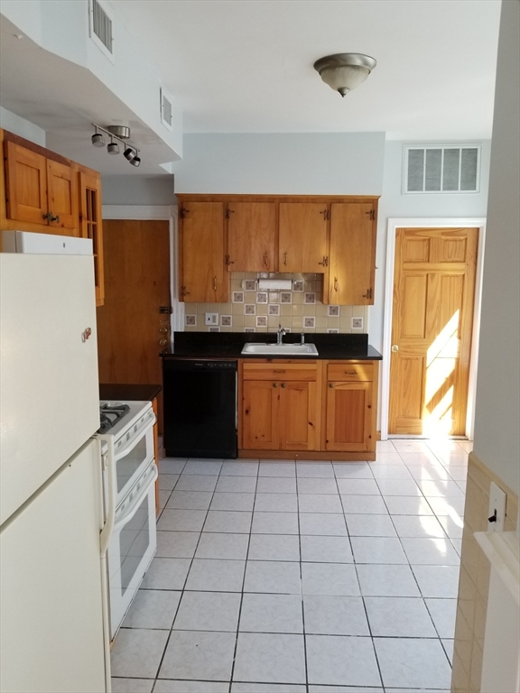 341 Summer Street, Unit 2F Somerville, MA 02144 - Photo 16 of 17 a kitchen with stainless steel appliances granite countertop a stove a sink and a refrigerator
