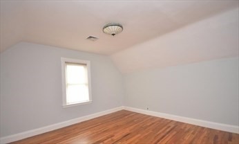 341 Summer Street, Unit 2F Somerville, MA 02144 - Photo 9 of 17 an empty room with wooden floor and windows