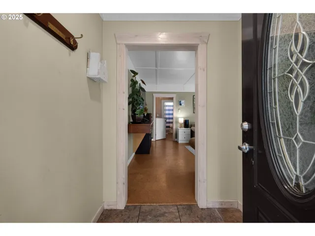 a view of a hallway with wooden floor windows and a bathroom