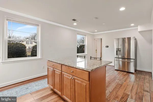 a kitchen with stainless steel appliances granite countertop a refrigerator a stove and a wooden floors