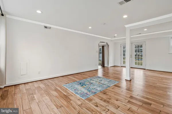 a view of an empty room with wooden floor and closet