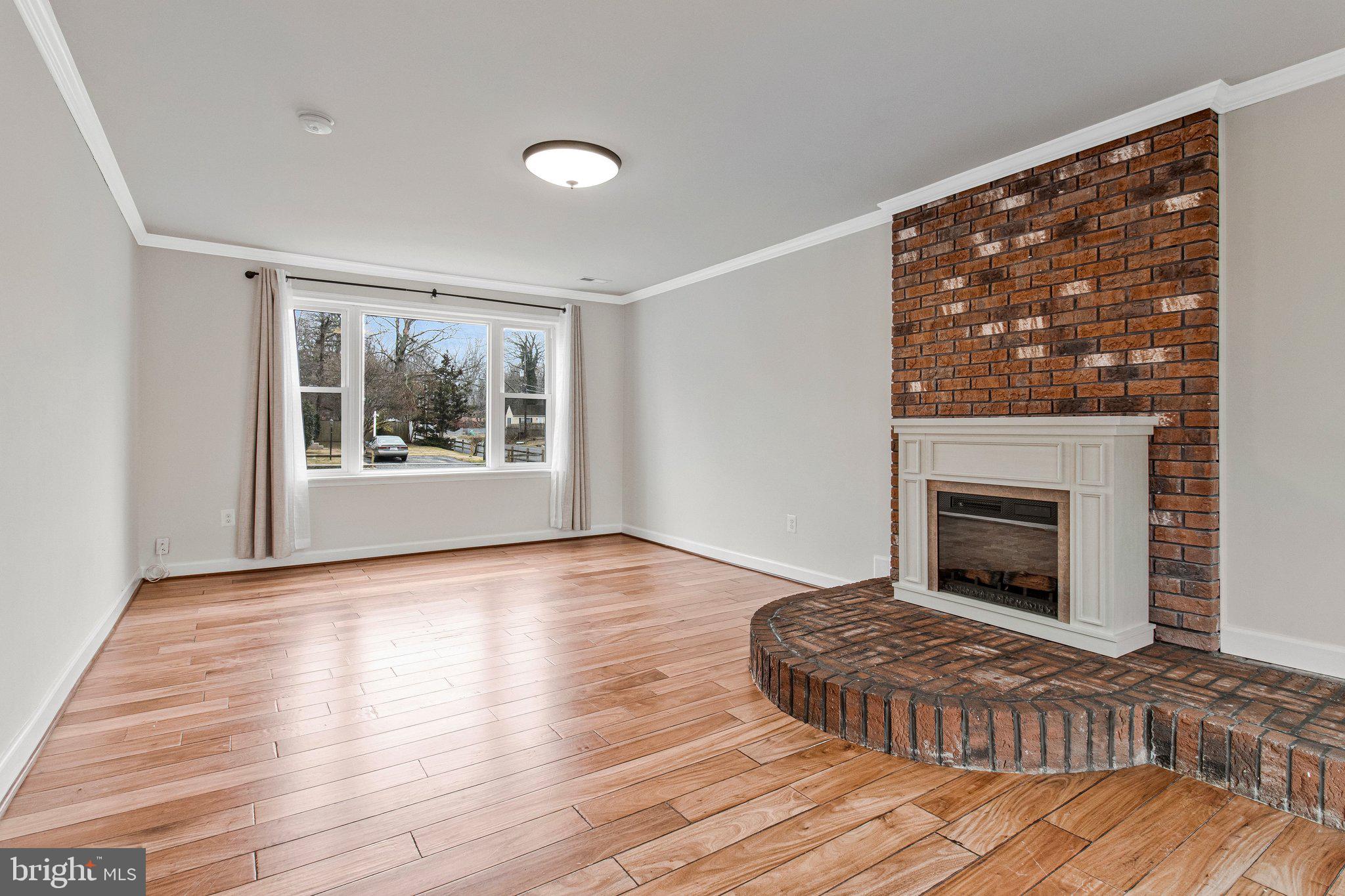 8600 Lantern Lane Clinton, MD 20735 - Photo 8 of 40 a view of a livingroom with wooden floor a fireplace and windows