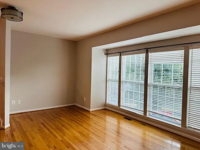 a view of a room with wooden floor and windows