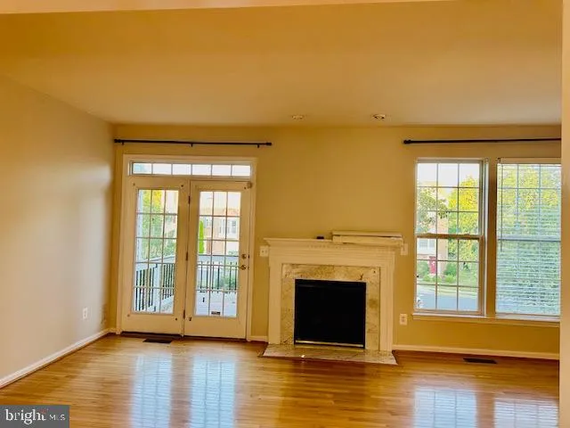 a view of empty room with wooden floor and fireplace