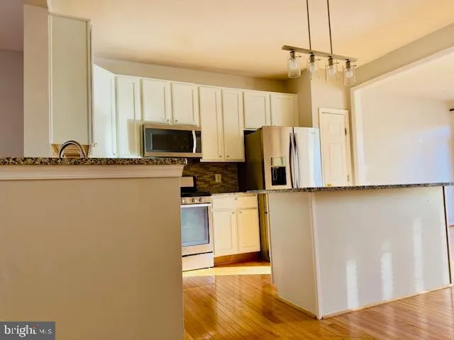 a kitchen with stainless steel appliances a refrigerator and a stove
